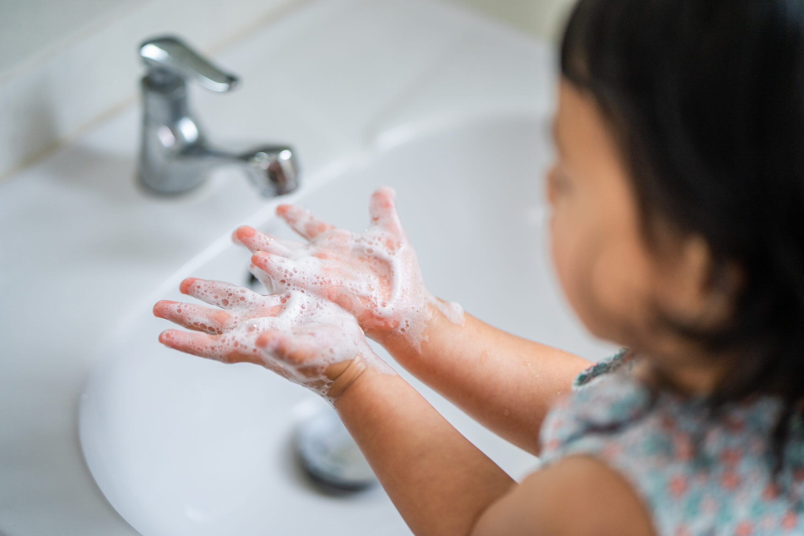 southeast asian female kid wash her hands lavatory prevent virus germs scaled